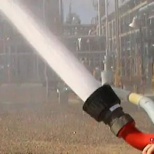 Foam monitor nozzle spraying firefighting foam onto a burning surface.